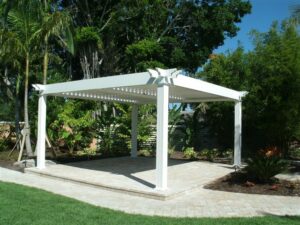 A freestanding white pergola surrounded by palm trees
