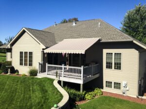 Picture of a house with a beautiful new retractable awning over the deck.