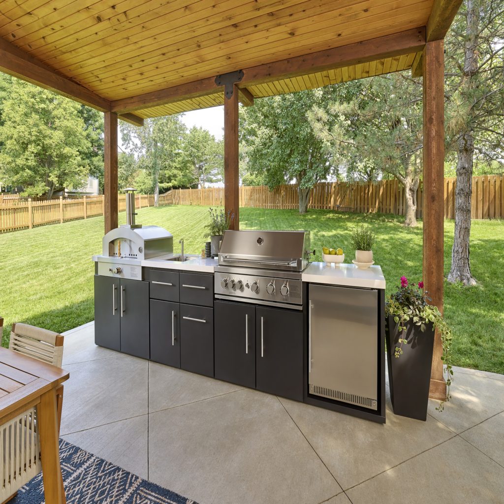 Emory 12-foot linear outdoor kitchen with pizza oven and grill station installed under a wood pavilion.